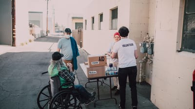 Des bénévoles distribuent de la nourriture et des médicaments aux personnes dans le besoin, démontrant compassion et soutien communautaire.