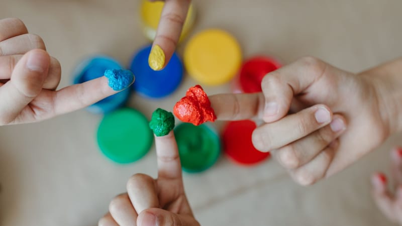 Des enfants explorant leur créativité avec de la peinture aux doigts colorée. Gros plan sur des mains et de la peinture.