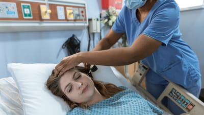 Une infirmière s'occupant d'un patient dans un cadre hospitalier, mettant en valeur des soins de santé professionnels.