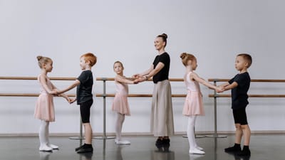 Un instructeur guide des enfants dans un cours de ballet, en se concentrant sur les bases de la danse.