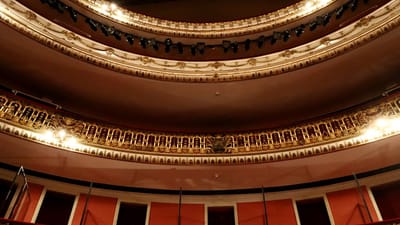 Intérieur de théâtre richement décoré avec des détails dorés et un éclairage spectaculaire.