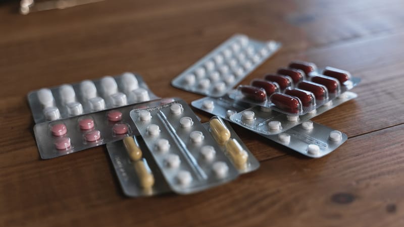 Une variété de pilules en plaquettes sur une surface en bois. Idéal pour un contenu lié à la santé.