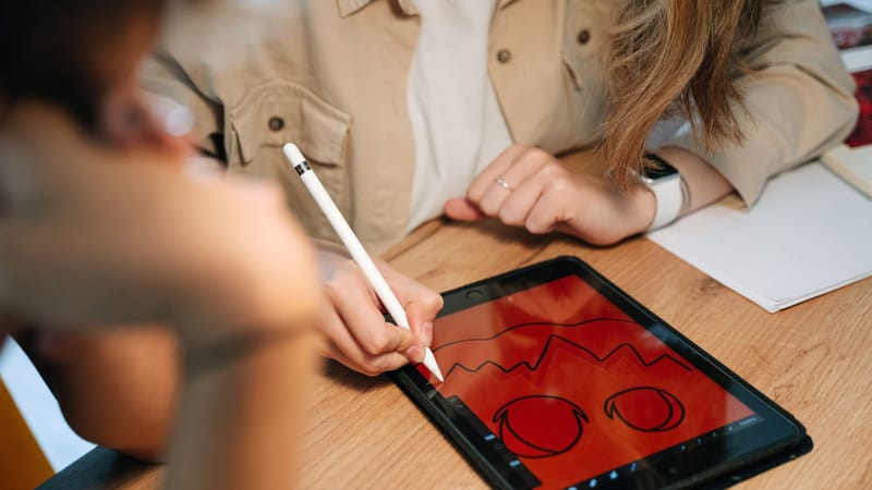 Une personne conçoit de manière créative une illustration sur le thème d'Halloween sur une tablette à l'aide d'un Apple Pencil. En intérieur.