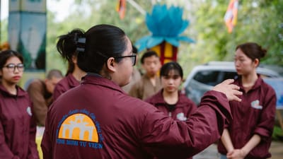 Groupe de personnes engagées dans une discussion lors d'un événement culturel en plein air.
