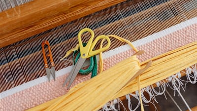 Fil coloré et outils sur un métier à tisser montrant l'art du tissage.