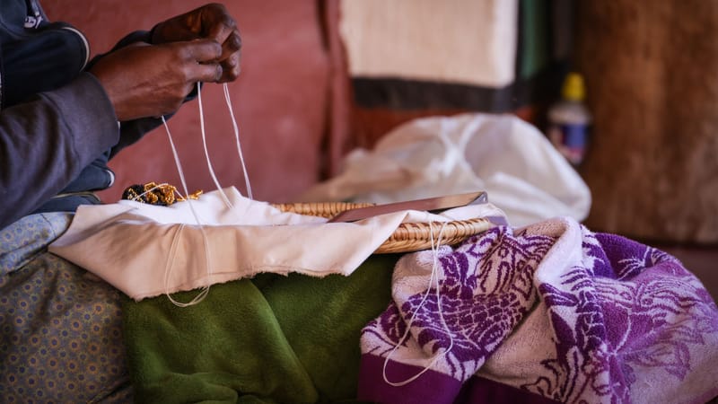 Fabrication artisanale de motifs de perles complexes à l'intérieur, mettant l'accent sur les compétences artisanales traditionnelles.