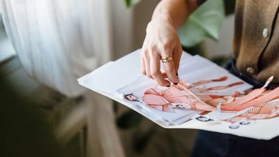 Un designer de mode examinant des croquis colorés dans un environnement de studio bien éclairé.