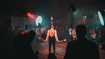 Un jongleur fascinant de cirque se produit sous un éclairage dramatique lors d'un festival animé.