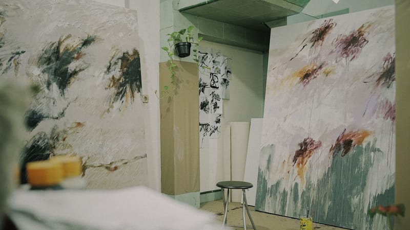 Un studio d'art confortable avec des peintures abstraites expressives et de la créativité en cours.