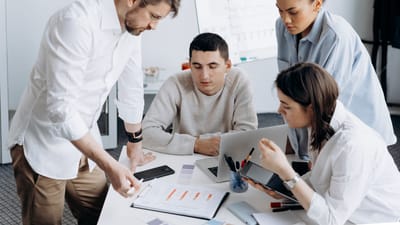 Un groupe de professionnels en brainstorming et travaillant ensemble dans un bureau contemporain.