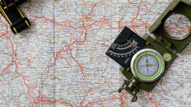 Vue rapprochée d'une boussole sur une carte détaillée, idéale pour les concepts de voyage et de navigation.