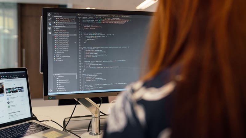 Une ingénieure travaille sur un code dans un cadre de bureau contemporain, mettant en avant le développement logiciel.