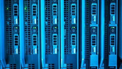 Image détaillée de racks de serveurs éclairés mettant en avant l'infrastructure technologique moderne.