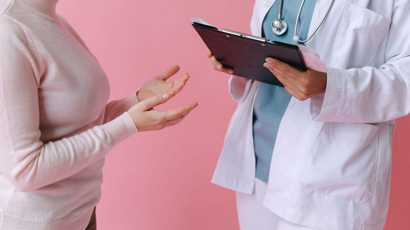 Gros plan sur un patient consultant un médecin avec un clipboard dans un cadre médical.