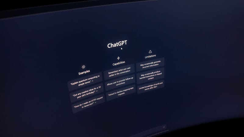 Gros plan sur un écran d'ordinateur affichant l'interface de ChatGPT dans un environnement sombre.
