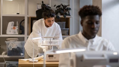 Jeunes couturiers travaillant attentivement aux machines à coudre dans un cadre d'atelier contemporain.