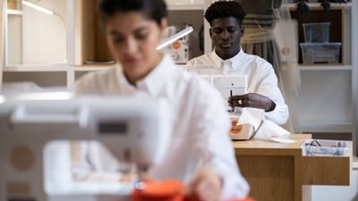 Des designers de mode concentrés sur la couture dans un environnement de studio moderne.