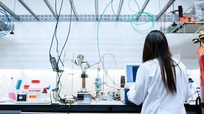 Une scientifique effectuant des recherches dans un laboratoire contemporain rempli d'équipements.
