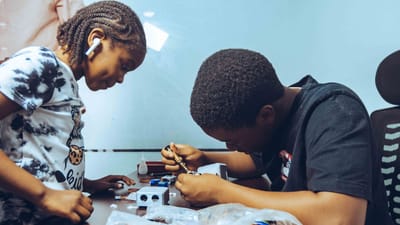 Deux étudiants engagés dans un apprentissage pratique de l'électronique dans un cadre de classe à Accra, au Ghana.