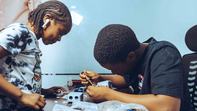 Deux étudiants engagés dans un apprentissage pratique de l'électronique dans un cadre de classe à Accra, au Ghana.