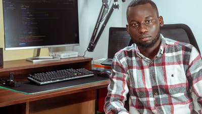 Portrait d'un développeur codant dans un environnement de bureau moderne, mettant en avant la technologie et la concentration.
