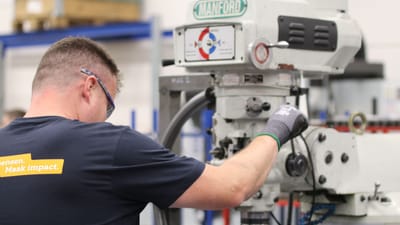 Un ouvrier utilise une fraiseuse Manford dans un environnement industriel, démontrant précision et efficacité.