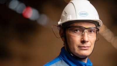 Ingénieur masculin confiant portant un casque de sécurité et des lunettes dans un cadre industriel.