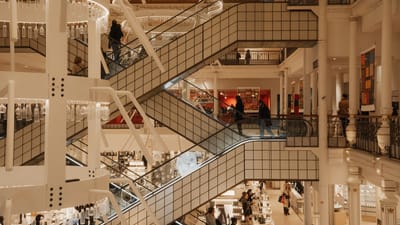 Découvrez la beauté architecturale d'un centre commercial parisien moderne, avec ses élégants escaliers mécaniques et son design géométrique.