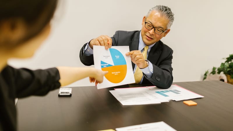 Environnement professionnel avec des collègues discutant des graphiques lors d'une réunion d'affaires.