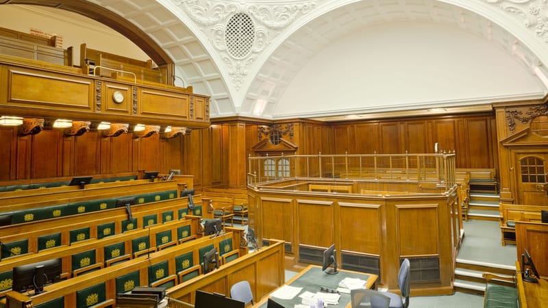 Vue intérieure d'une salle d'audience historique à Londres avec un design orné et un mobilier en bois.