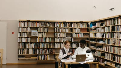 Deux étudiants divers travaillent ensemble dans une bibliothèque.