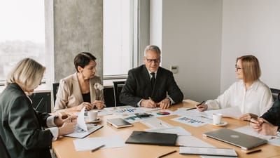 Un groupe de professionnels discutant de documents d'affaires lors d'une réunion dans un bureau moderne.