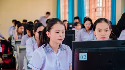 Groupe d'élèves de lycée concentrés sur l'apprentissage dans un laboratoire informatique.