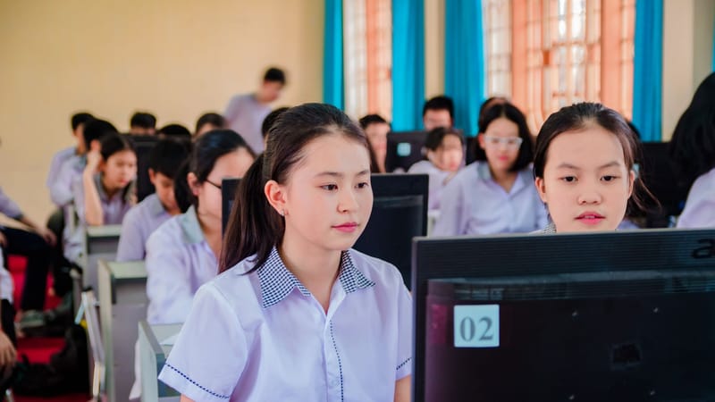 Groupe d'élèves de lycée concentrés sur l'apprentissage dans un laboratoire informatique.