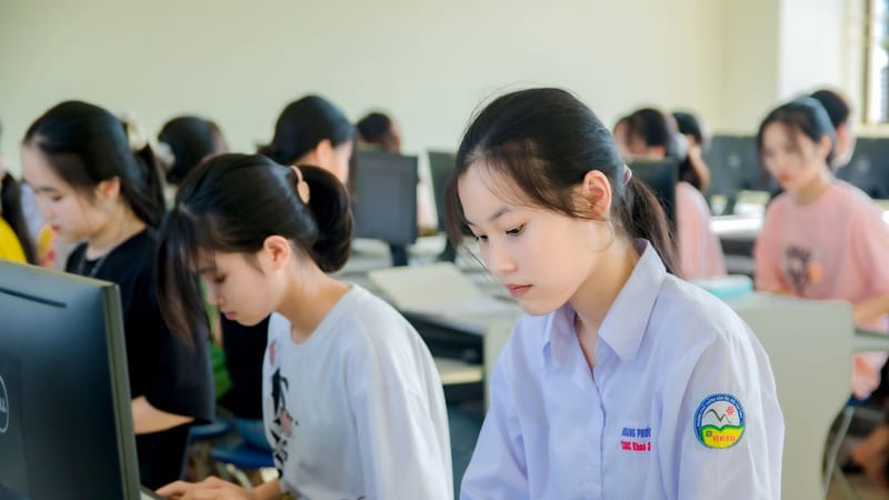 Jeunes femmes asiatiques concentrées sur leurs études dans un laboratoire informatique universitaire.