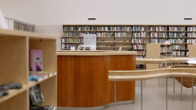 Bibliothèque universitaire contemporaine avec du mobilier en bois et une vaste collection de livres.