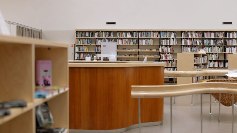 Bibliothèque universitaire contemporaine avec du mobilier en bois et une vaste collection de livres.