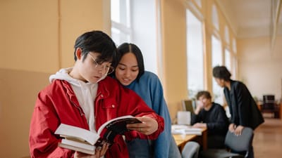 Groupe d'étudiants lisant et étudiant ensemble dans une bibliothèque.