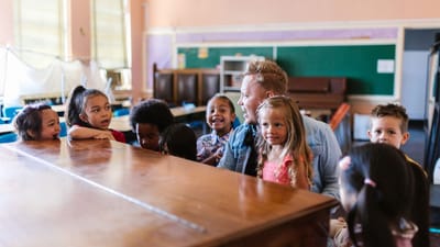 Un groupe d'enfants et un enseignant profitant d'une séance d'apprentissage ludique dans une salle de classe.