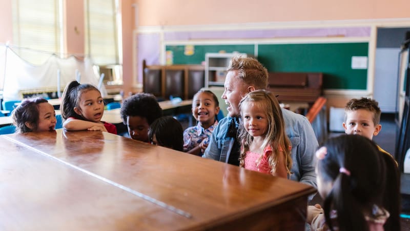 Un groupe d'enfants et un enseignant profitant d'une séance d'apprentissage ludique dans une salle de classe.