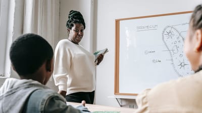 Enseignant expliquant un diagramme de paramécie à des élèves dans une salle de classe interactive.