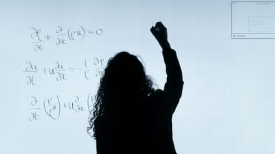 Une silhouette de femme écrivant des équations mathématiques sur un grand tableau blanc, représentant l'éducation et l'analyse.