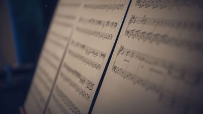 Image en gros plan de partitions musicales en flou doux avec un éclairage d'ambiance, parfait pour des concepts artistiques.