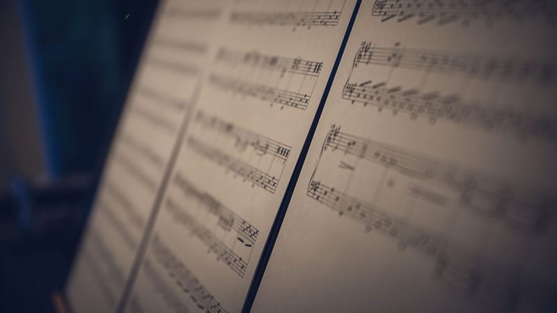 Image en gros plan de partitions musicales en flou doux avec un éclairage d'ambiance, parfait pour des concepts artistiques.