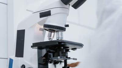 Vue détaillée d'un scientifique utilisant un microscope dans un laboratoire.