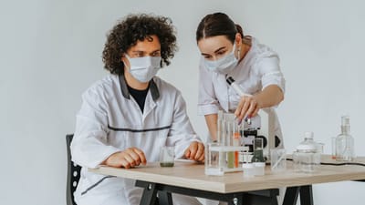 Deux scientifiques travaillant sur des expériences dans un laboratoire avec des microscopes et des éprouvettes.