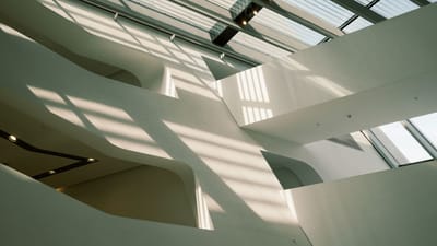 Architecture intérieure minimaliste avec des lucarnes et des ombres géométriques, parfaite pour l'inspiration design.