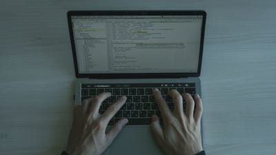 Vue rapprochée d'un programmeur codant sur un ordinateur portable, mettant en avant le développement de logiciels modernes.