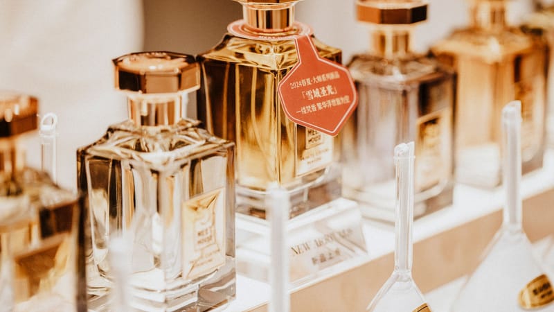 Collection élégante de bouteilles de parfum mettant en avant des fragrances de luxe dans une présentation de vente au détail stylée.