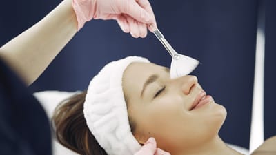 Femme profitant d'un soin du visage relaxant dans un spa, mettant en avant les soins de la peau et la relaxation.